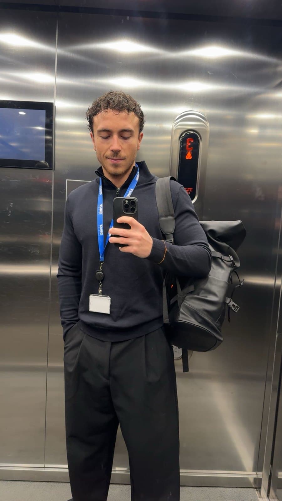 Mauro in de lift bij KPMG, met badge om.